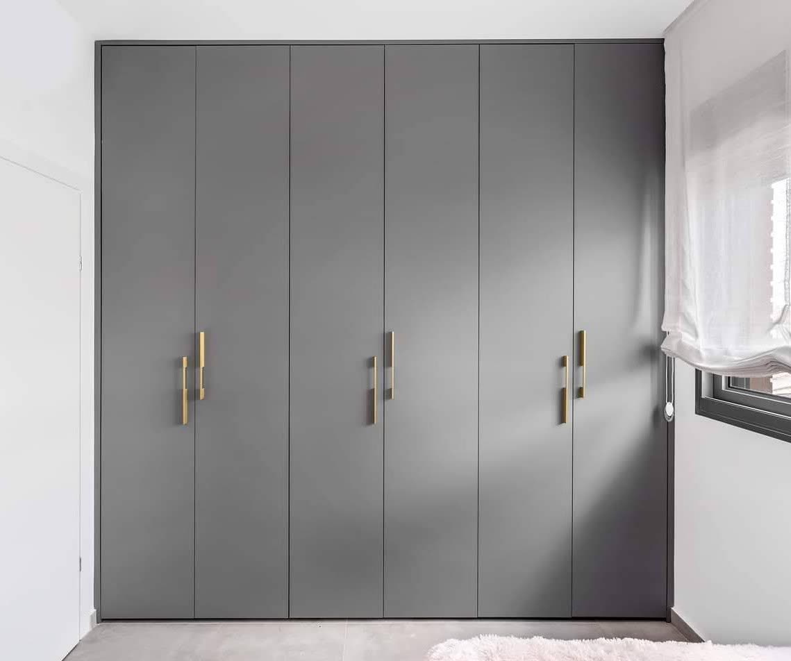 Boutique-style gray wardrobe cabinetry with brass pulls by iKitchen Cabinetry