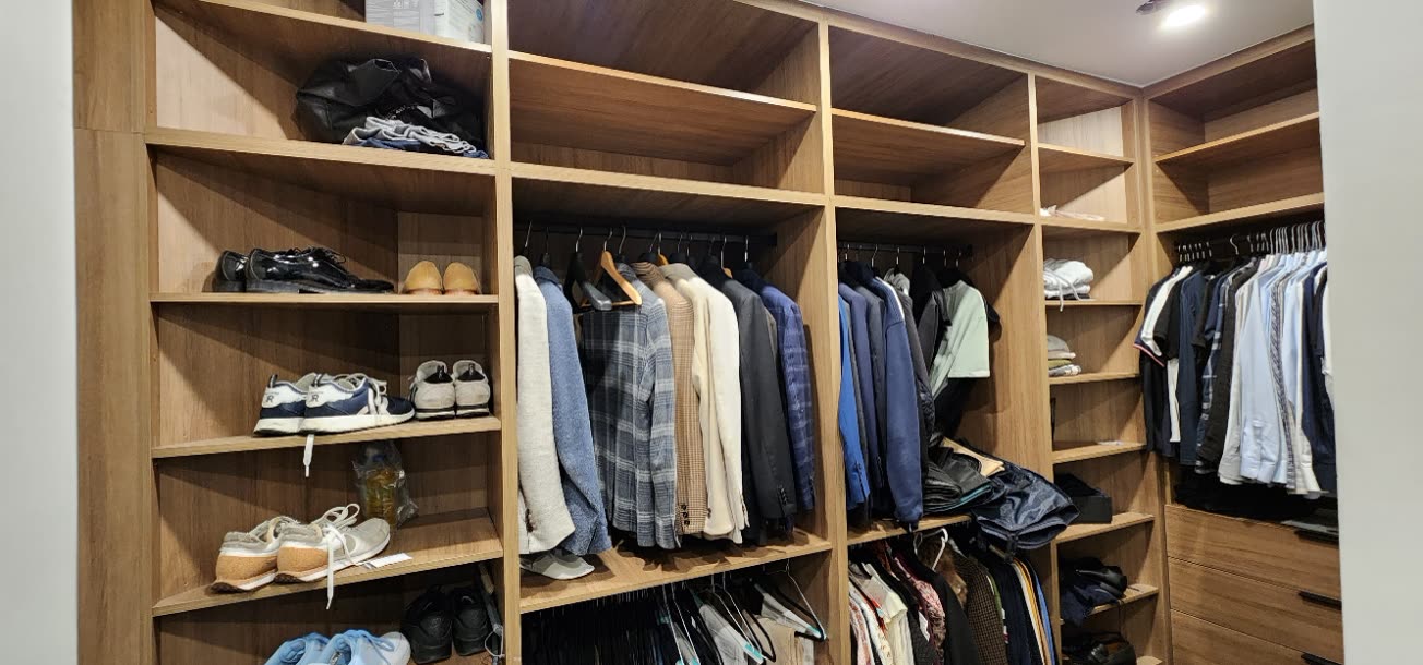 Custom closet cabinetry fitted to an irregular room with drawers and hanging by iKitchen Cabinetry