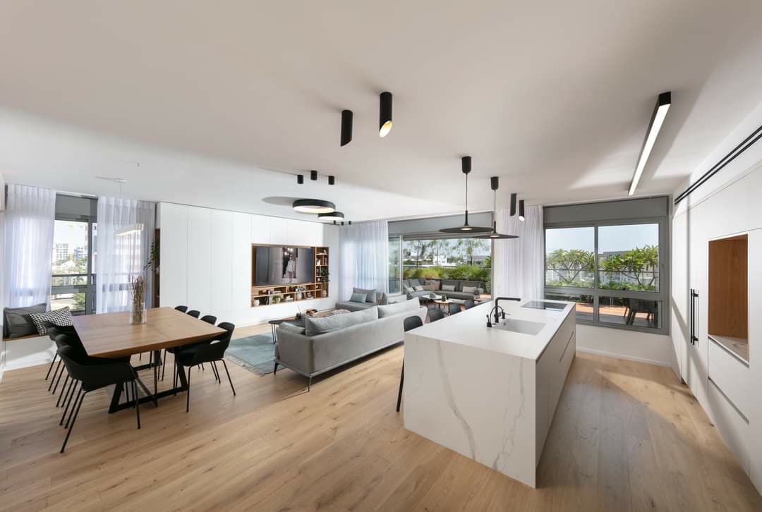 Bright modern kitchen with white marble waterfall island in an open plan by iKitchen Cabinetry