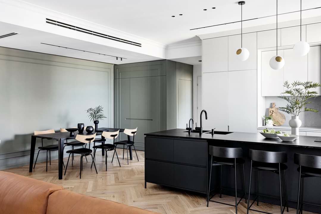 Sage-green paneled transitional kitchen with black island and herringbone floor by iKitchen Cabinetry