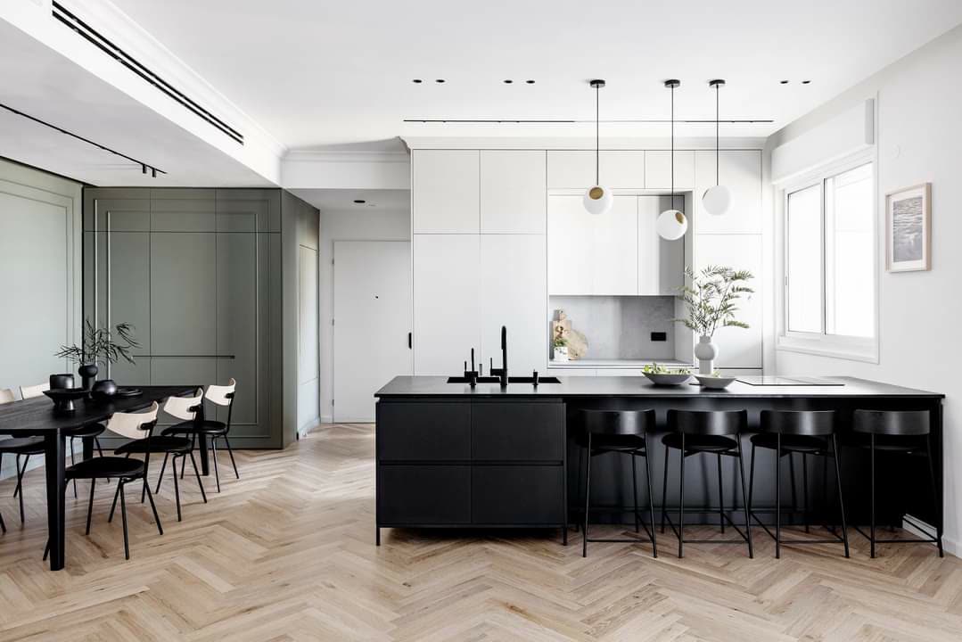 Transitional kitchen mixing classic paneled cabinetry with a modern black island by iKitchen Cabinetry