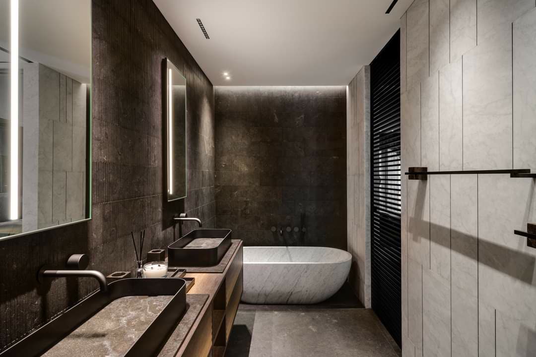 Comfort-height custom vanity with drawer bank and integrated stone countertop in a modern bathroom